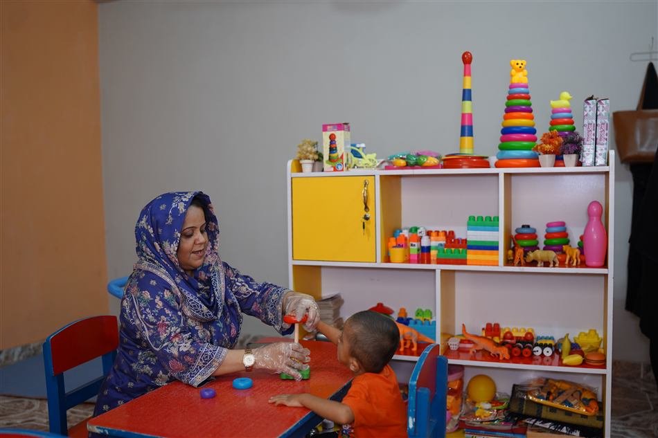 Therapist working with a toddler on a stacking toy