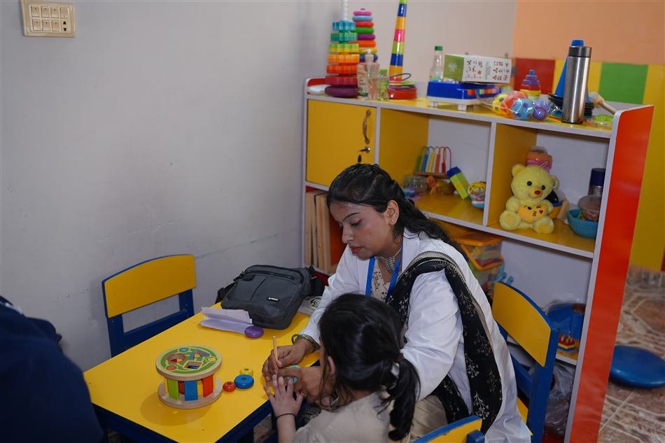 Therapist guiding a child through a shape-sorting exercise