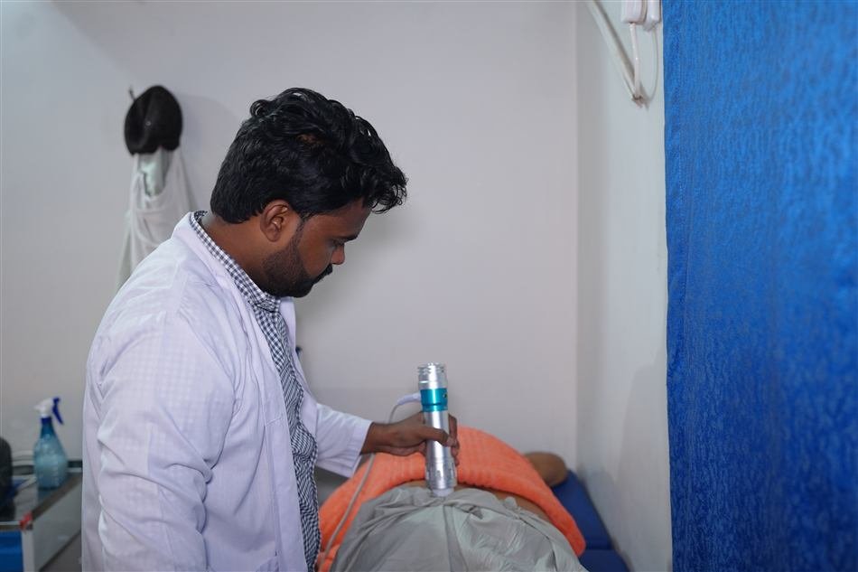 Physiotherapist applying shockwave therapy to a patient